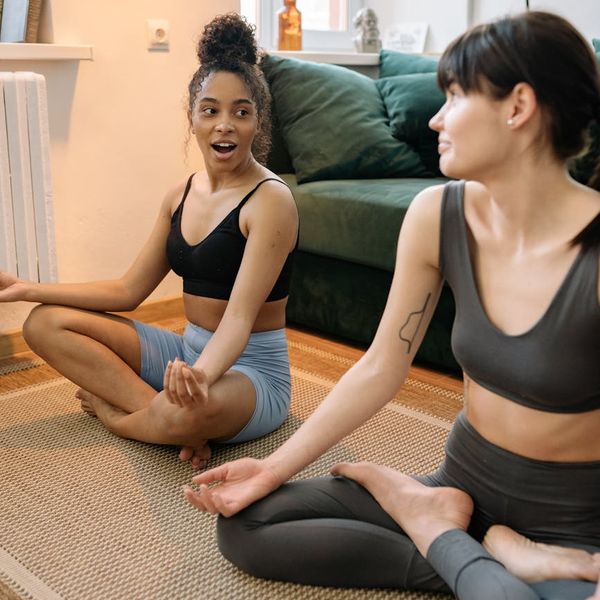 Smiling woman sitting comfortably after a yoga session, looking refreshed.
