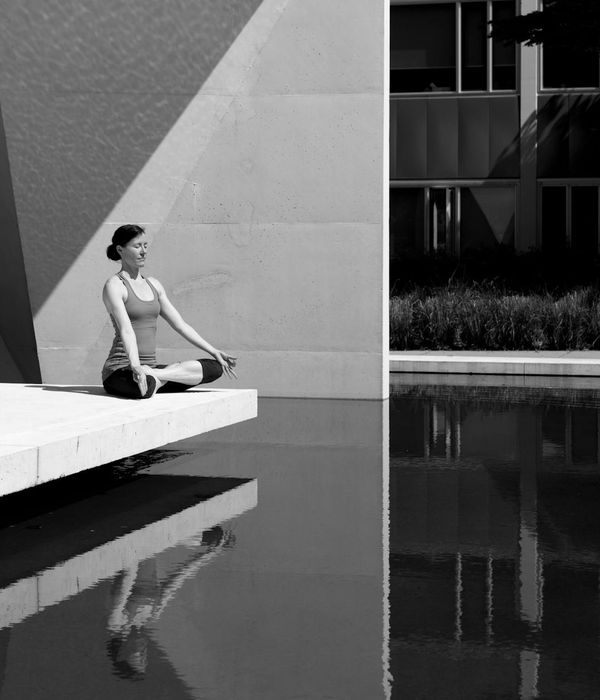 Woman in a serene yoga pose in a calm, minimalist environment.